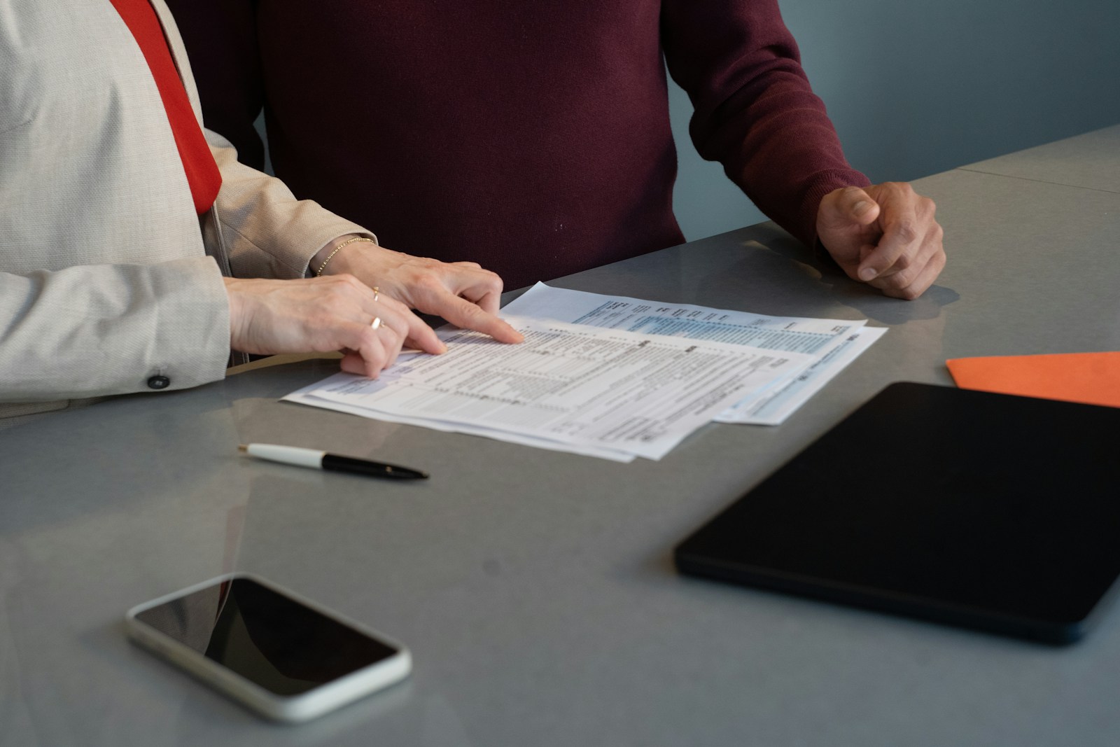 Dos profesionales revisan documentación en una mesa de trabajo